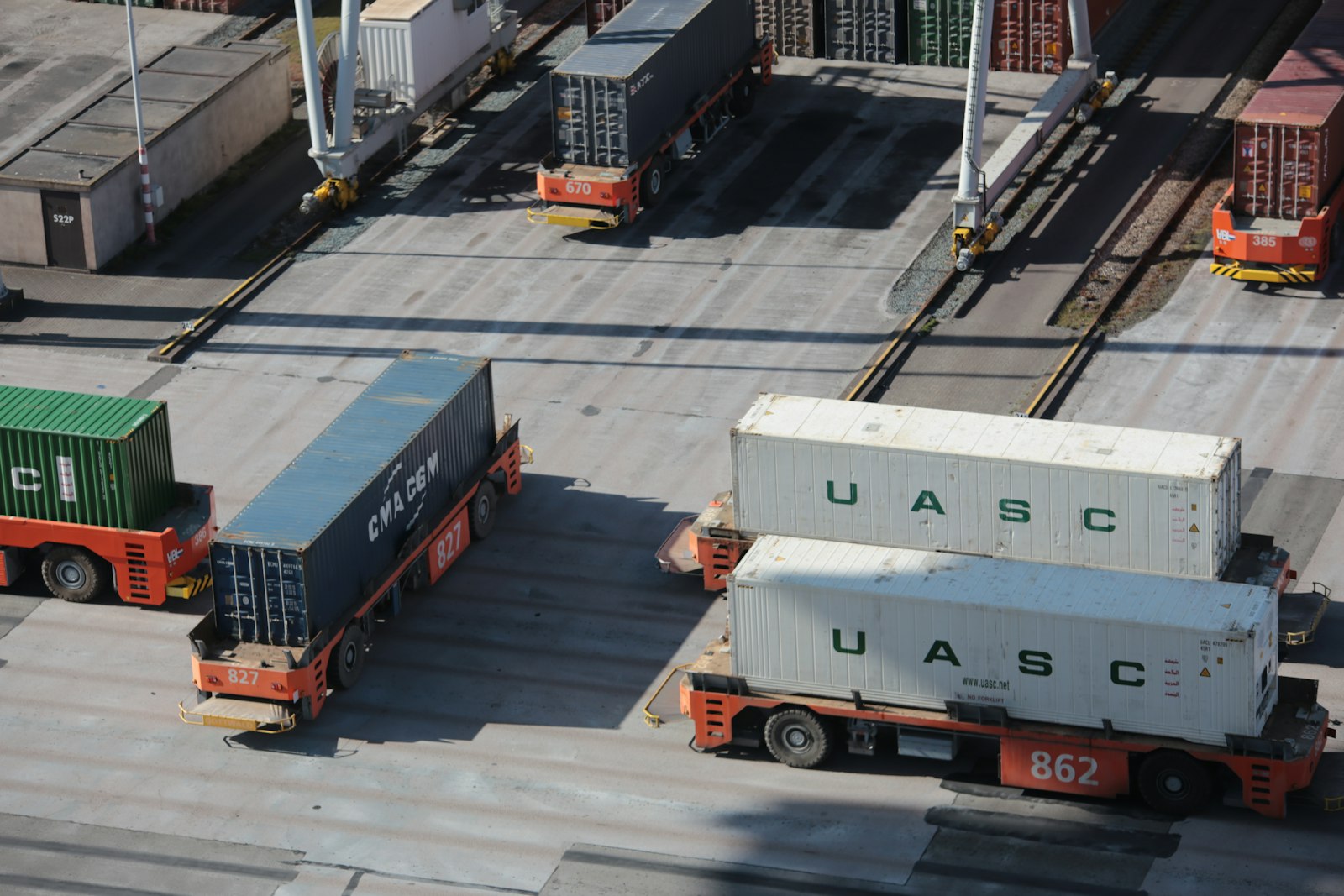 Containers de carga e veículos autônomos num pátio de operação portuária. Foto: Bernd Dittrich / Unsplash